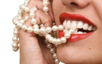 Žena sa lepim zubima je zagrizla bisernu ogrlicu